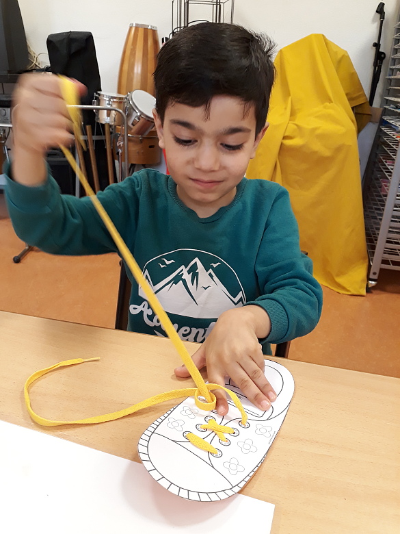 Vorschulkind beim Schleife binden