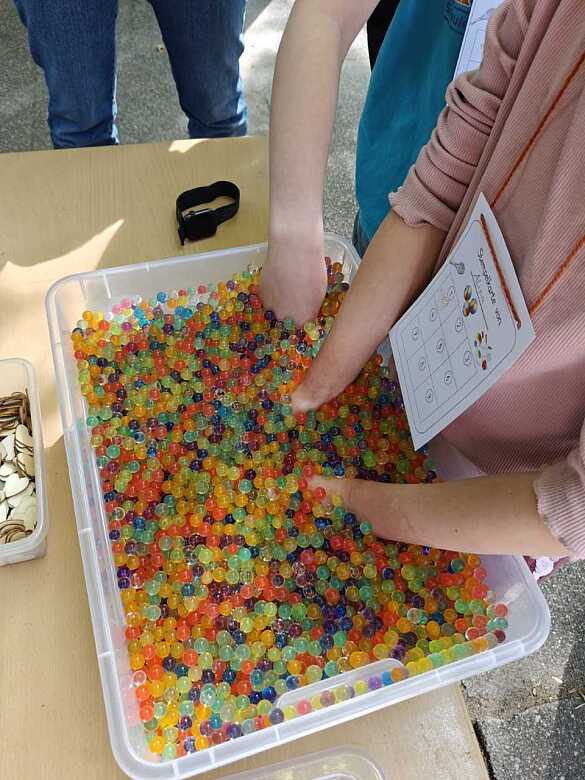 Ein Kind erfühlt Gegenstände im Wasserperlenbad.